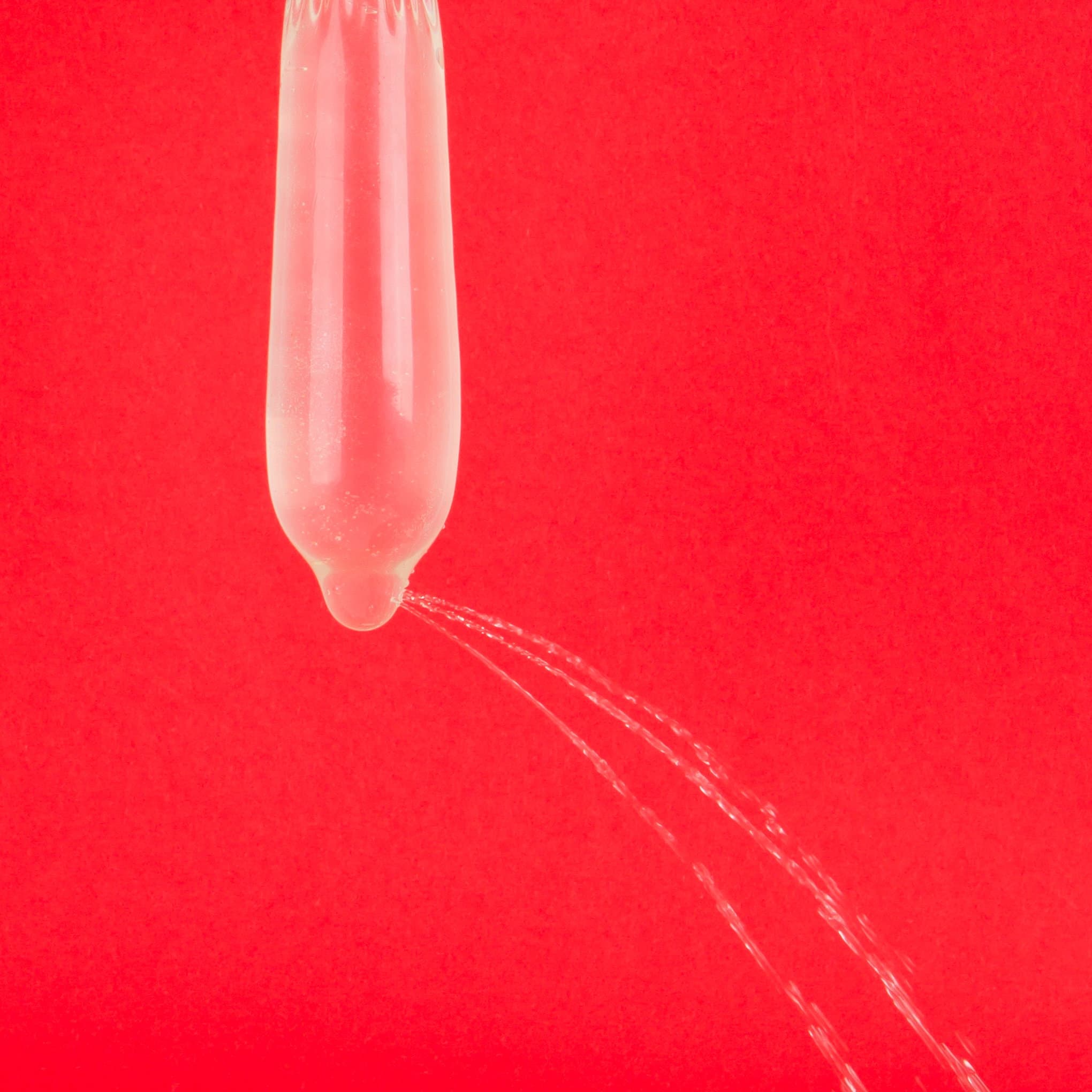 Elongated transparent balloon against a red background.