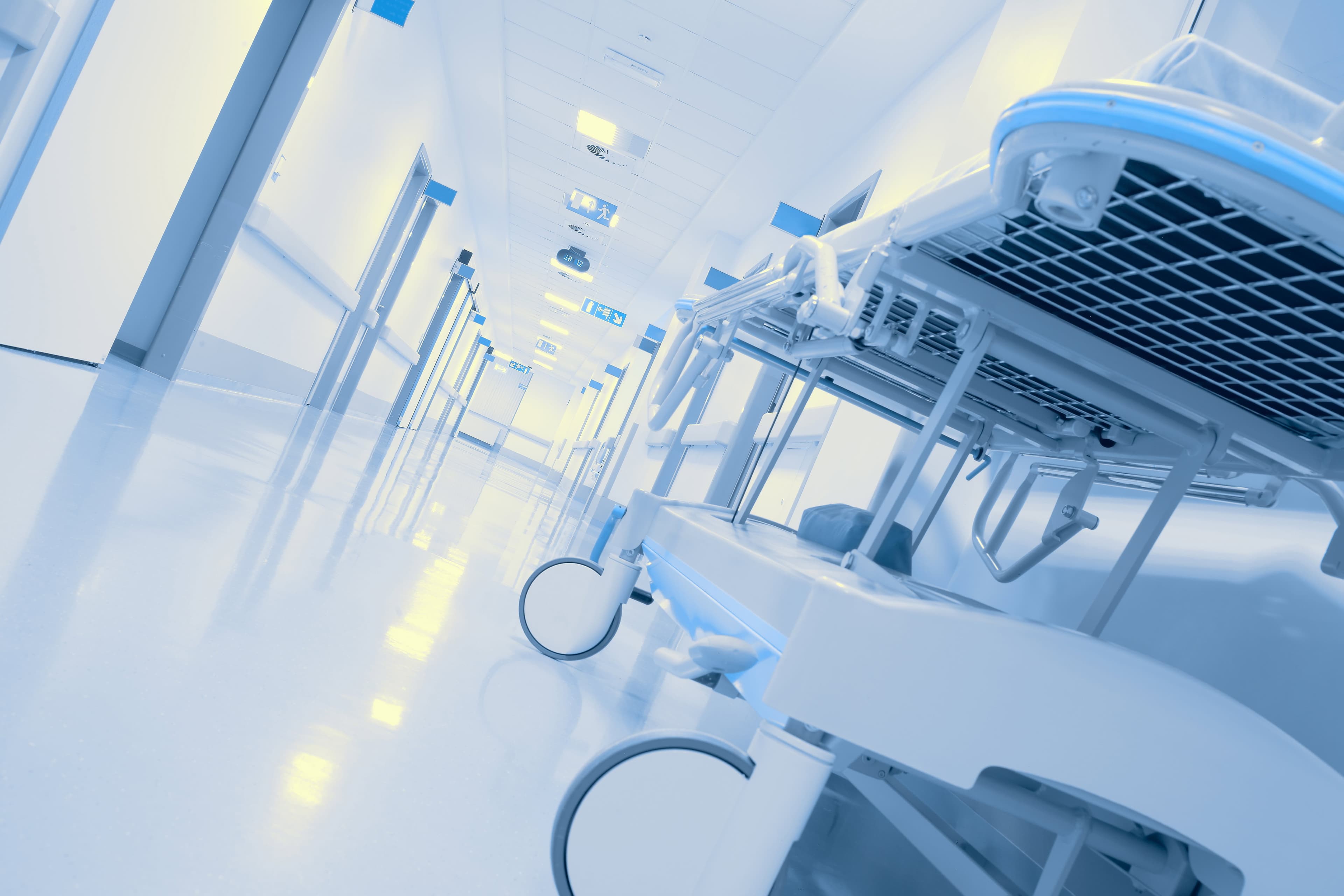 Stanza ospedaliera con letto e apparecchiature mediche.