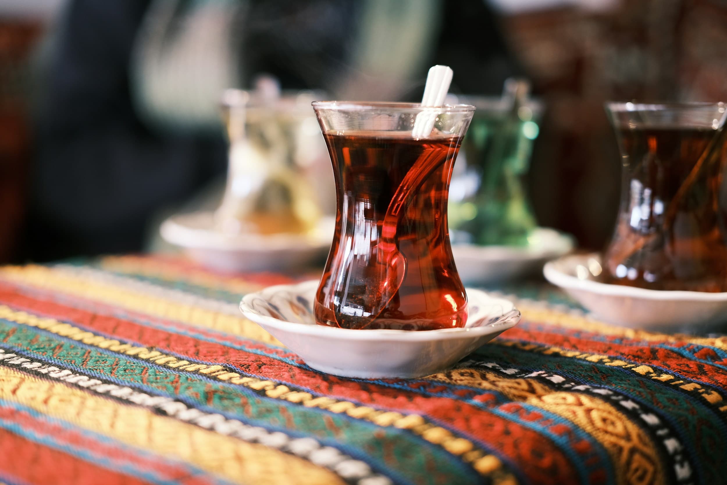 كوب شاي تركي على صحن ومفرش مزخرف.
